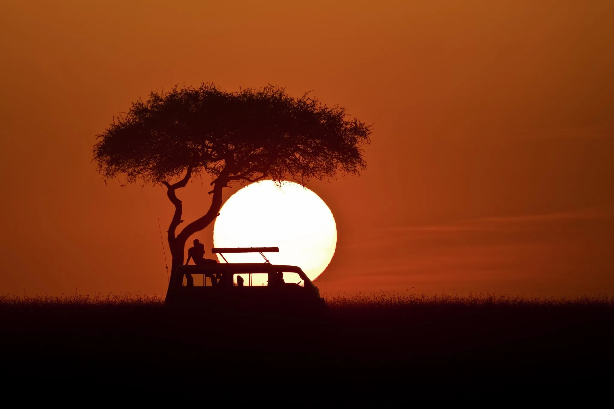 Sunset with safari car silhouette at Masai Mara