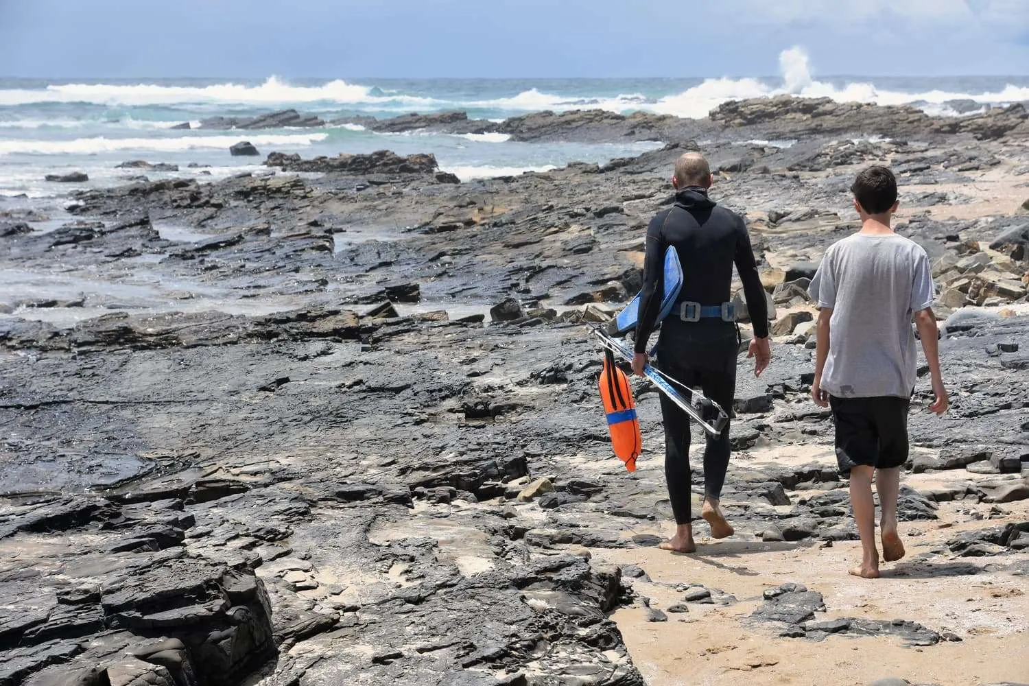 fisher walking near the shoreline, coffee bay, eastern cape, the wild coast